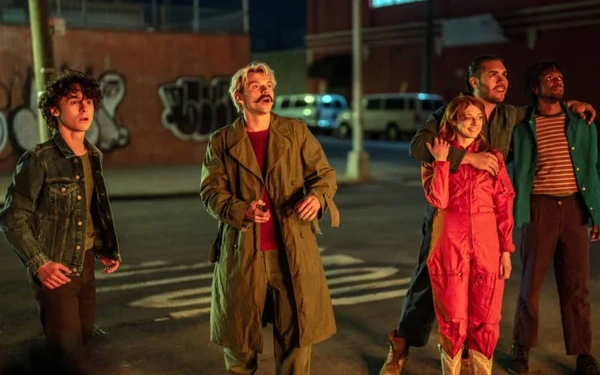 《Cidade em Chamas》中夜间街道上的一群人物。