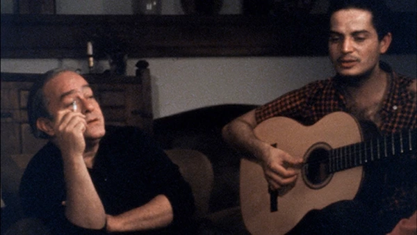A man plays guitar as another listens in "Os Afro-Sambas: O Brasil de Baden e Vinícius".