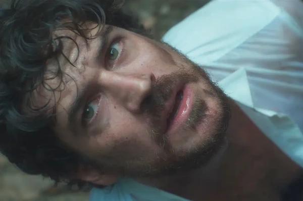 A close - up of the male lead in Cidade Invisível 2, showing a tired and expressive face.