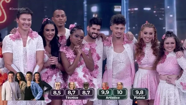 Contestants of Dança dos Famosos pose together in stylish pink - themed outfits.